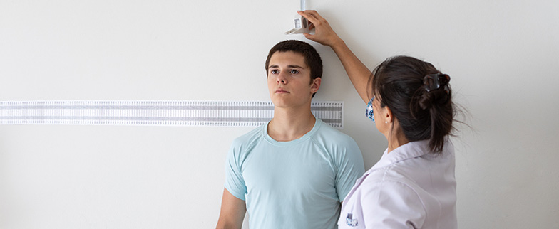 Teen having his height measured for BMI.