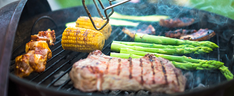 Barbecuing vegetables and meat on a grill.