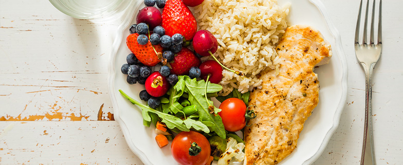 Healthy chicken, rice and salad meal.