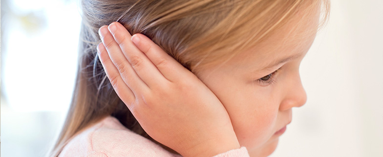 Girl holding ear in pain.